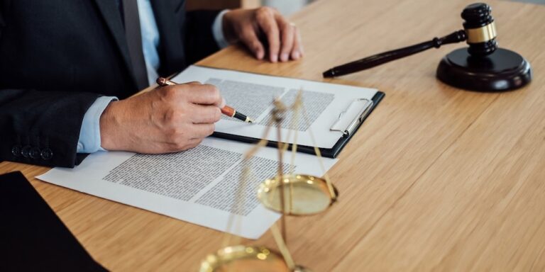 Gavel on wooden table and Lawyer or Judge working with agreement in Courtroom theme, Justice and Law concept
